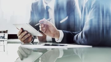 Corporate businessmen working on tablet at office